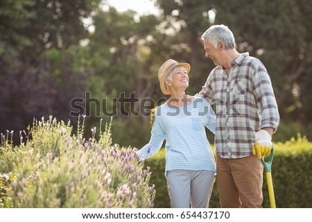 Happy senior couple standing in backyard Royalty-Free Stock Photo #654437170