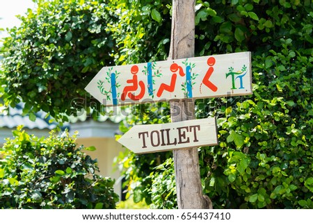 Signs toilet Restroom male- female and people living with disabilities with an arrow showing direction on nature background.