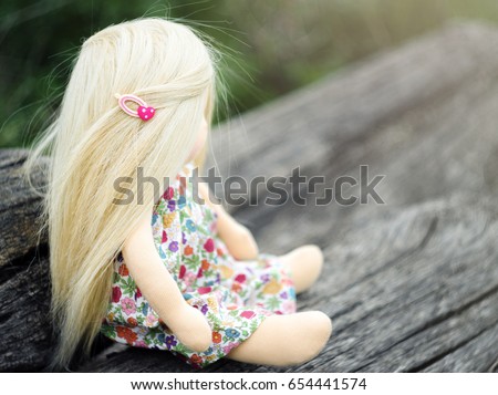 Hand made textile waldorf girl doll sitting on wood