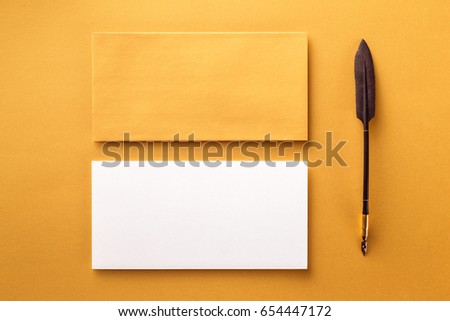 Mockup of envelope, blank white paper and vintage ink pen at golden paper background.