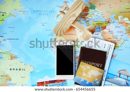 Smartphone, passport and credit cards on world map background