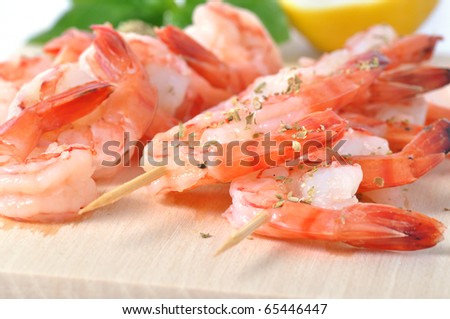 Shrimps, lemon, and basil on board isolated on white background
