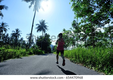 healthy lifestyle woman runner running on morning tropical forest trail
