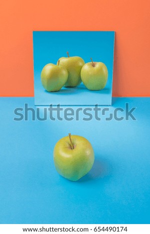 Picture of apple on blue table isolated over orange background