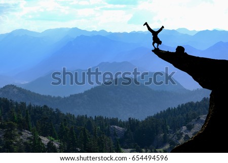 bravest man in the cliff & Risky movement Royalty-Free Stock Photo #654494596