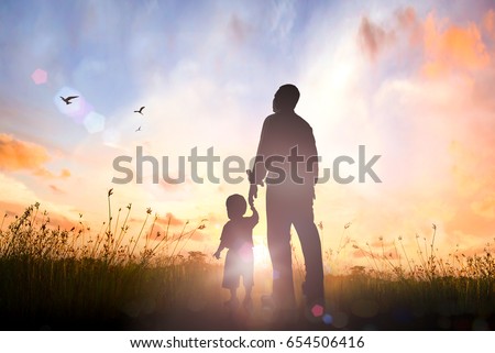 Happy Father's Day concept: Silhouette Father and son standing on meadow autumn sunrise background Royalty-Free Stock Photo #654506416