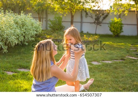 happy family mother and daughter hugging in summer on the nature