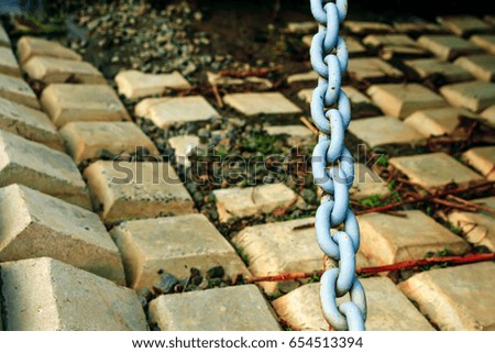 Old blue massive chain on the background of concrete tiles