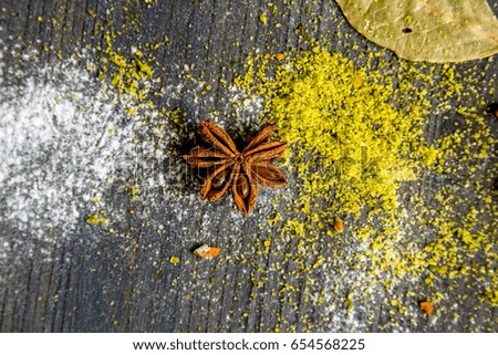 Star anise, curry and flour on wooden background