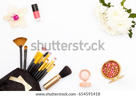 makeup brush in my purse, nail Polish, flowers, chrysanthemums and orchids and other cosmetics on a white background. Minimal feminine beauty concept. Flat lay. Top view.