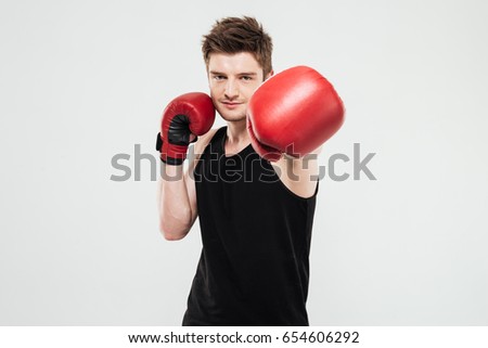 Picture of concentrated young sportsman boxer standing isolated over white background. Looking at camera.