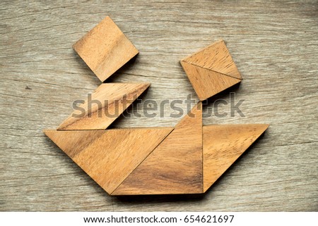 Wooden tangram puzzle in couple sailing the boat shape background (Concept for love and travel)
