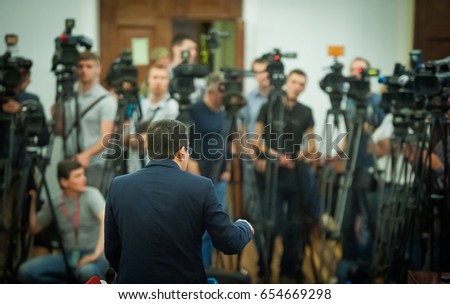 Press conference. Public speaker giving talk to Television camera. News conference. An event with a video camera. press and media in public news coverage event for reporter and mass communication