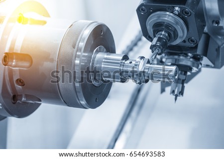 The CNC lathe machine or Turning machine  drilling the metal rod with the drill tool and center drill tool .The hi-technology machining concept. Royalty-Free Stock Photo #654693583