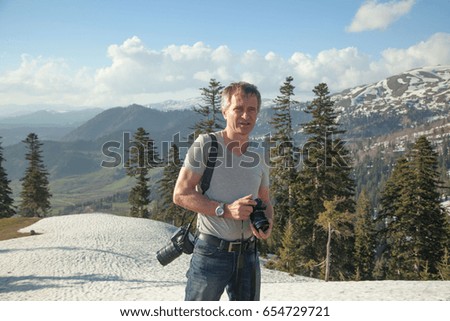 Nature photographer with two digital cameras in the mountains