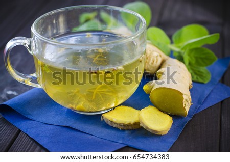 Herbal tea with mint and ginger on a wooden table