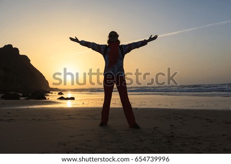 Happy woman at sunset on the beach