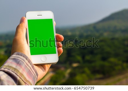 Mobile Phone in hand with natural view and rising up 
