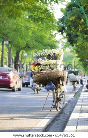 Life in Vietnam. The flower bike of vendors, parked along the yellow-dyed by sun light in afternoon street. Beauty is peaceful and friendly.Beautiful Chrysanthemum Flower background.