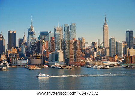 New York City skyline panorama over Hudson river with Empire State Building, boat and skyscraper.