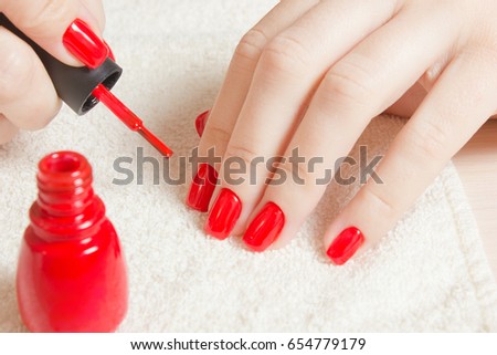 Manicure - Beautiful manicured woman's nails with red nail polish on soft white towel. Royalty-Free Stock Photo #654779179