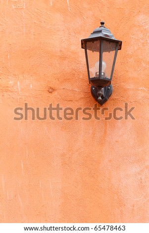 An old italian lamp isolated on orange wall Royalty-Free Stock Photo #65478463
