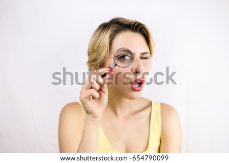 Young woman looking for something through a magnifier lens, concept of research.