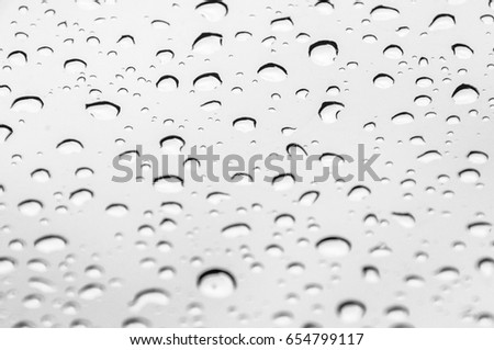 close up shot on droplets of the rain on window glass. Natural Pattern of raindrops isolated on cloudy background.