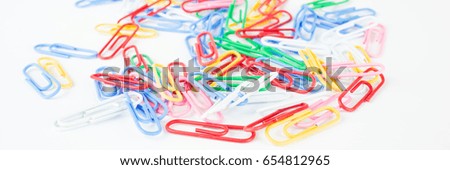 Many colorful office clamps on white background, banner