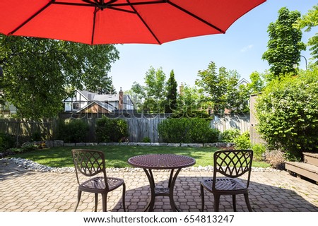 Backyard Garden with Bright Orange Cantilever Umbrella and Bistro Set