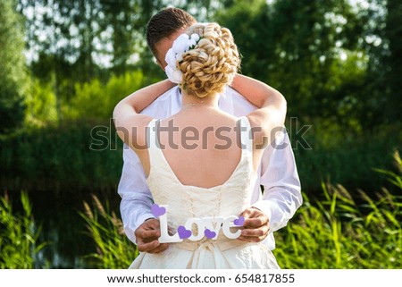 The bride and groom in nature. The love words. Conceptual image. Happy couple on their wedding day.