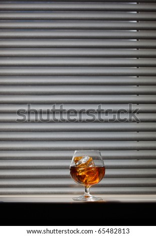 Whisky glass with ice on a window sill