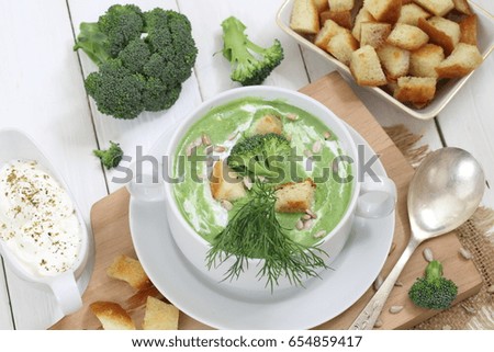 Soup puree with broccoli in white soup stock on a wooden background
