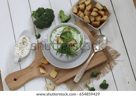 Soup puree with broccoli in white soup stock on a wooden background
