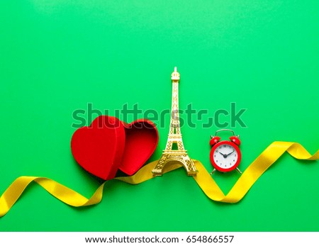 Heart shape box and Eiffel tower toy with ribbon on green background