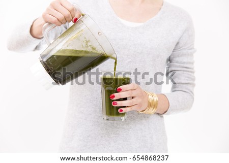 Woman filling glass with smoothie for breakfast