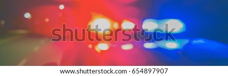 Night patrolling the city. Red and blue Lights of police car in night time. Abstract blurry image.