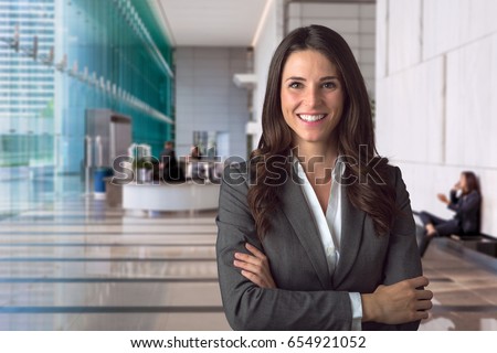 Smiling bank manager welcoming warm personality bright big smile in large building Royalty-Free Stock Photo #654921052