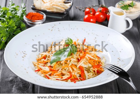 Fresh salad with apple, carrot, cabbage, celery and lemon on wooden background close up. Healthy food