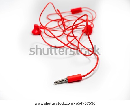 Red earphone on white background.Soft focus.