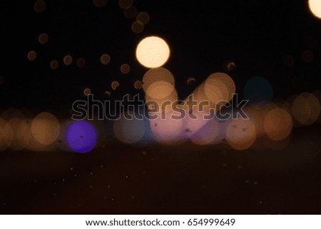 blur traffic view through a car windscreen covered in rain for background