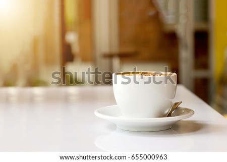 ceramic cup with hot latte coffee baverage on table in morning