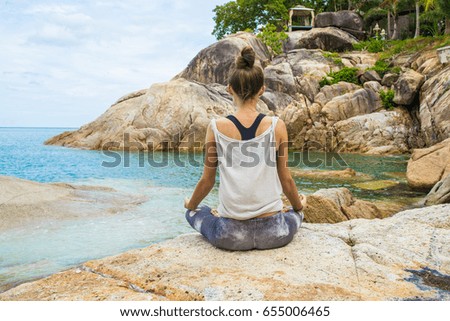 The woman practices yoga at dawn, there is an asana on a stone, dawn and an image of the girl, to enjoy dawn, to be happy with life, a beautiful body, ideal yoga,The girl meditates