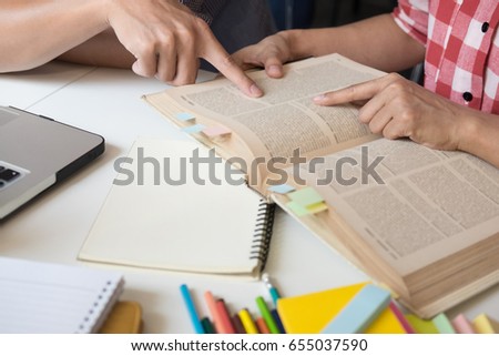 Young woman and man studying for a test/ an exam. Tutor books with friends. Young students campus helps friend catching up and learning. People, learning, education and school concept