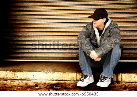 Skater sitting down on a ledge with a grunge style background