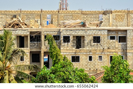 Construction site. Nice photo of unfinished building on a town background. Contemporary urban landscape. Developing of modern civil engineering. Construction industry. Close up.