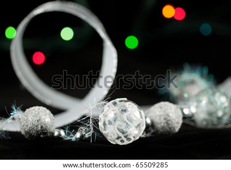 Silver christmas balls and colorful lights on the black background