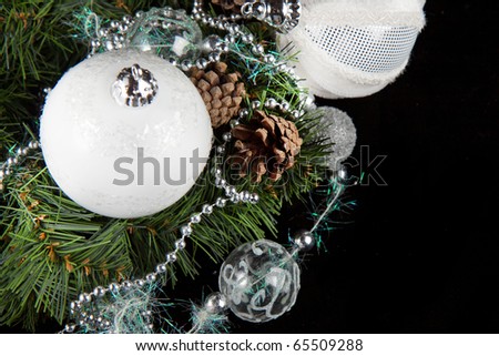 White and silver christmas balls with a christmas tree on the black background