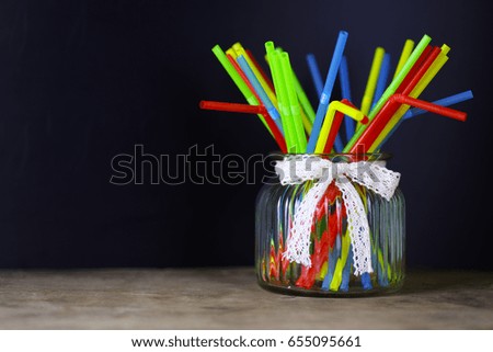 colored plastic cocktail tubes standing in a glass side view