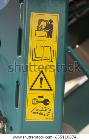 Warning sign on farm machinery. Read the user manual before operation. Before starting maintenance and repair, the engine must be off and the key out of the ignition.